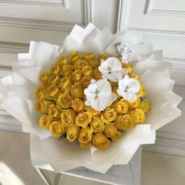 Bouquet of yellow roses with white orchids wrapped in white paper