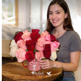 Woman holding a pink mug filled with red and pink roses