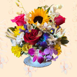 Colorful mixed bouquet with a sunflower, roses, and orchids in a vase