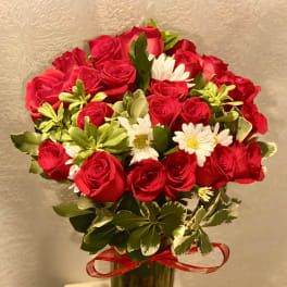Bouquet of red roses and white daisies in a glass vase