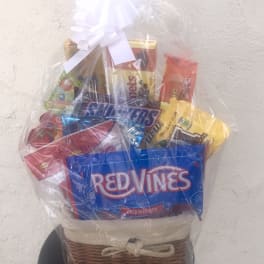 Gift basket of assorted candy wrapped in clear cellophane with a white bow