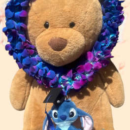 Teddy bear with a blue-purple flower lei and a small plush character hanging from it