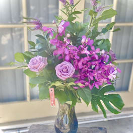 Pink roses and purple orchids in a glass vase