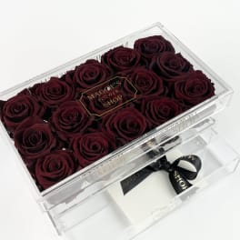 Box of deep red roses in a clear acrylic case
