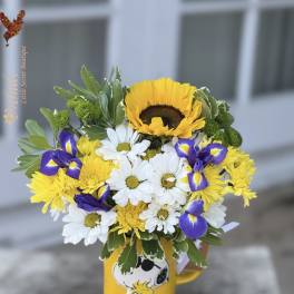 Bouquet of yellow, white, and purple flowers in a Snoopy mug