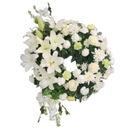 White floral wreath with lilies, roses, and daisies