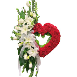 Heart-shaped red floral wreath with white lilies and roses