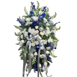 Tall blue and white floral standing spray with a silver ribbon bow