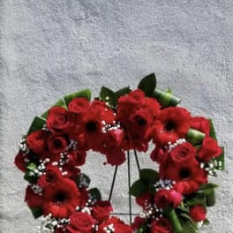 Heart-shaped red flower wreath on a stand