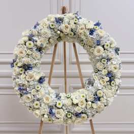 Large white floral wreath on a wooden easel