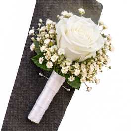 White rose boutonniere with baby's breath on a dark suit lapel