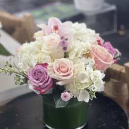 Pink and white roses with hydrangeas in a glass vase