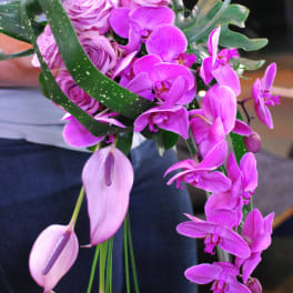Pink roses and purple orchids in a cascading bouquet