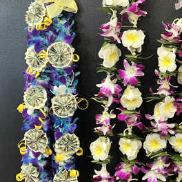 Lei-style floral garlands with white and purple flowers and money rosettes