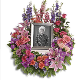 Floral memorial wreath with a framed photo in the center