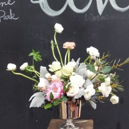 Pastel floral arrangement in a silver pedestal vase