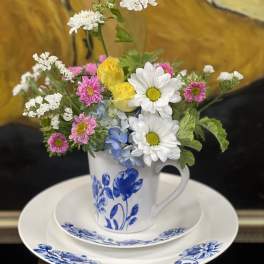 Mixed bouquet in a blue-and-white mug on a matching plate