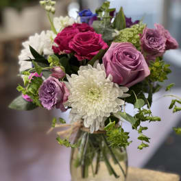Bouquet of pink and purple roses with white chrysanthemum in a glass vase