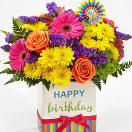 Birthday flower arrangement in a decorated gift box with a ribbon