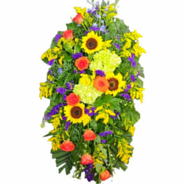 Standing floral spray with sunflowers, orange roses, and purple accents