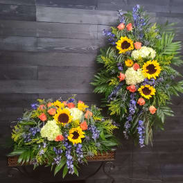 Two large floral sprays with sunflowers, roses, and hydrangeas on stands