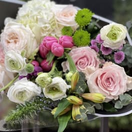 Bouquet of pink and white roses with ranunculus and green accents