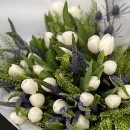 Bouquet of white tulips with purple spikes and green filler