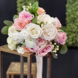 Bouquet of pink and white roses with greenery on a stand