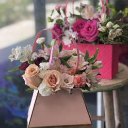 Pink and peach flower baskets with roses and alstroemeria