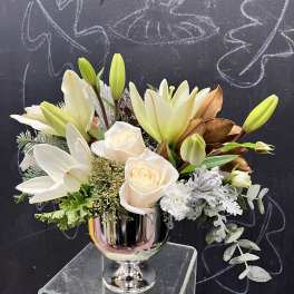 White lilies and roses arranged in a silver vase