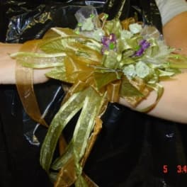 Gold ribbon wrist corsage with small purple and white flowers