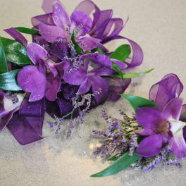 Purple orchid corsage and matching boutonniere with ribbon accents