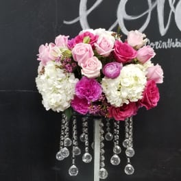 Pink and white rose arrangement on a tall stand with crystal strands