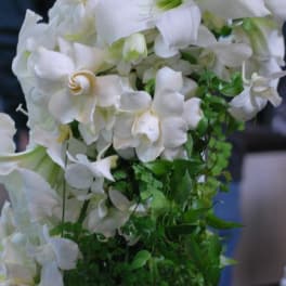 White floral arrangement with cascading green foliage