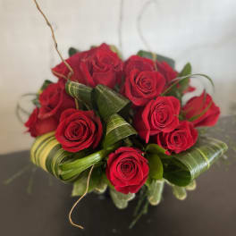 Bouquet of red roses with curled green leaves