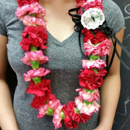 Woman wearing a lei of red and pink carnations with a black ribbon bow