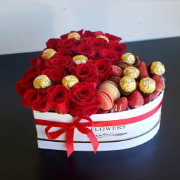 Heart-shaped box of red roses with chocolates and strawberries