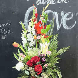 Red roses and mixed flowers in a red Christmas pot