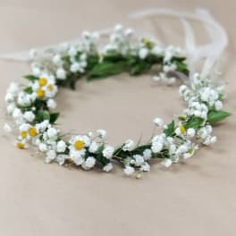 White floral crown with small yellow daisies on a ribbon tie
