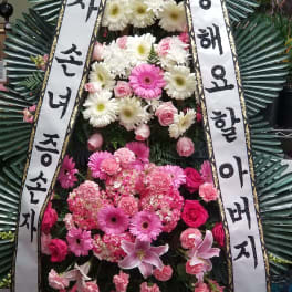 Standing funeral wreath with pink and white flowers and Korean condolence ribbons