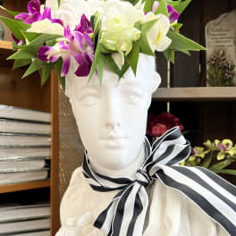 Floral crown of white and purple orchids on a white bust