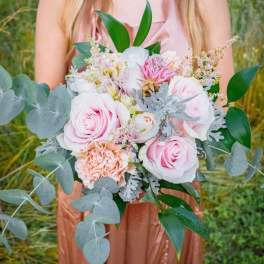 Bride holding a pastel bouquet of pink and white roses with eucalyptus