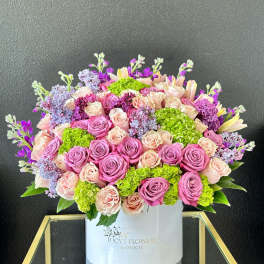 Large bouquet of pink and peach roses in a white box