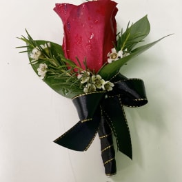 Single red rose boutonniere with small white flowers and a black ribbon