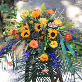 Colorful floral spray with sunflowers, roses, and blue flowers