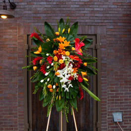 Large standing floral spray with red, orange, yellow, and white blooms