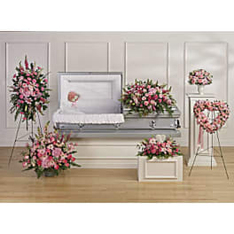 Pink and white funeral flower set with casket spray, standing sprays, and heart wreath around an open casket.