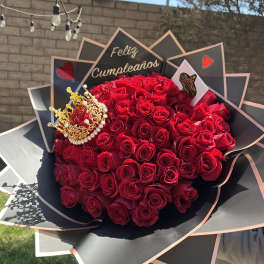 Large bouquet of red roses with a gold crown and birthday sign