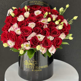 Red and white roses arranged in a black hatbox