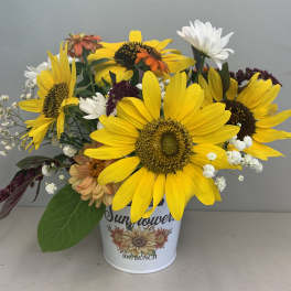 Sunflower bouquet in a white tin container with mixed accent flowers